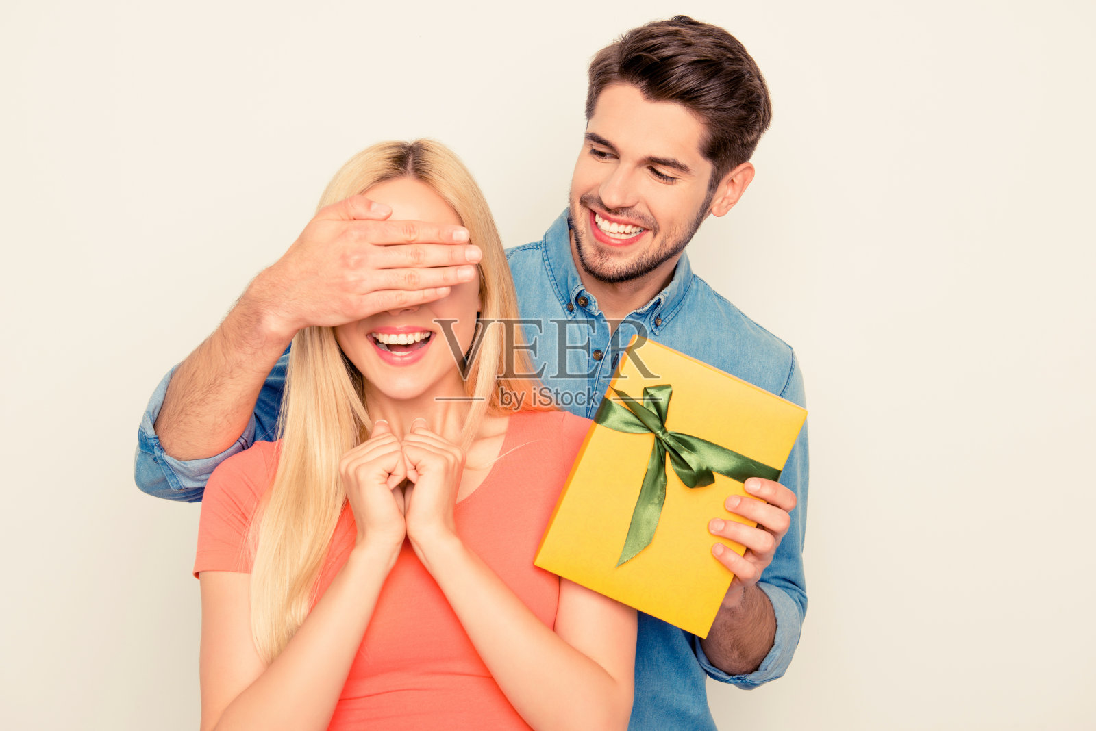 惊喜!一个男人闭上了他女朋友的眼睛，拿着礼物照片摄影图片