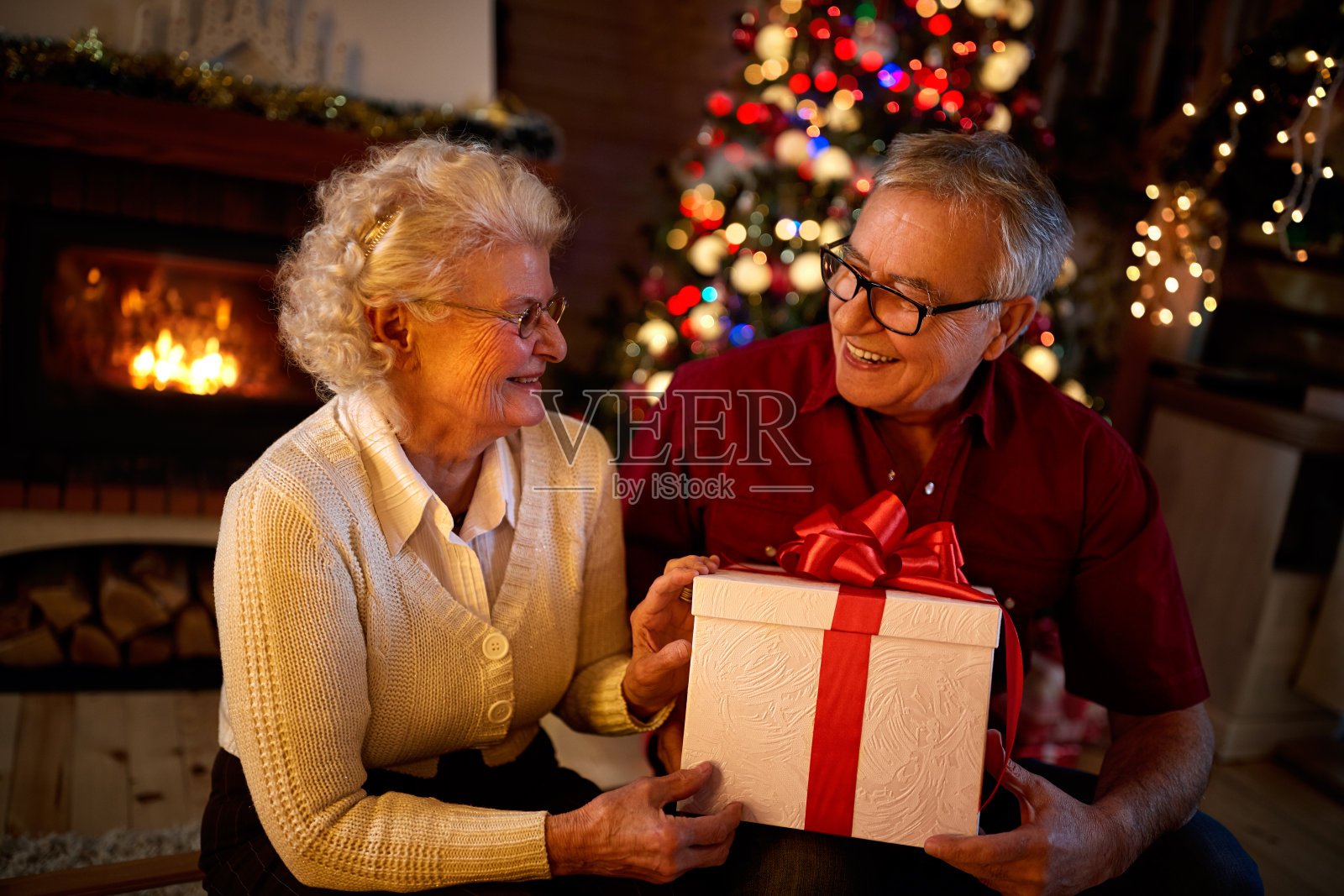 快乐的爷爷奶奶微笑着，拿着大礼物照片摄影图片