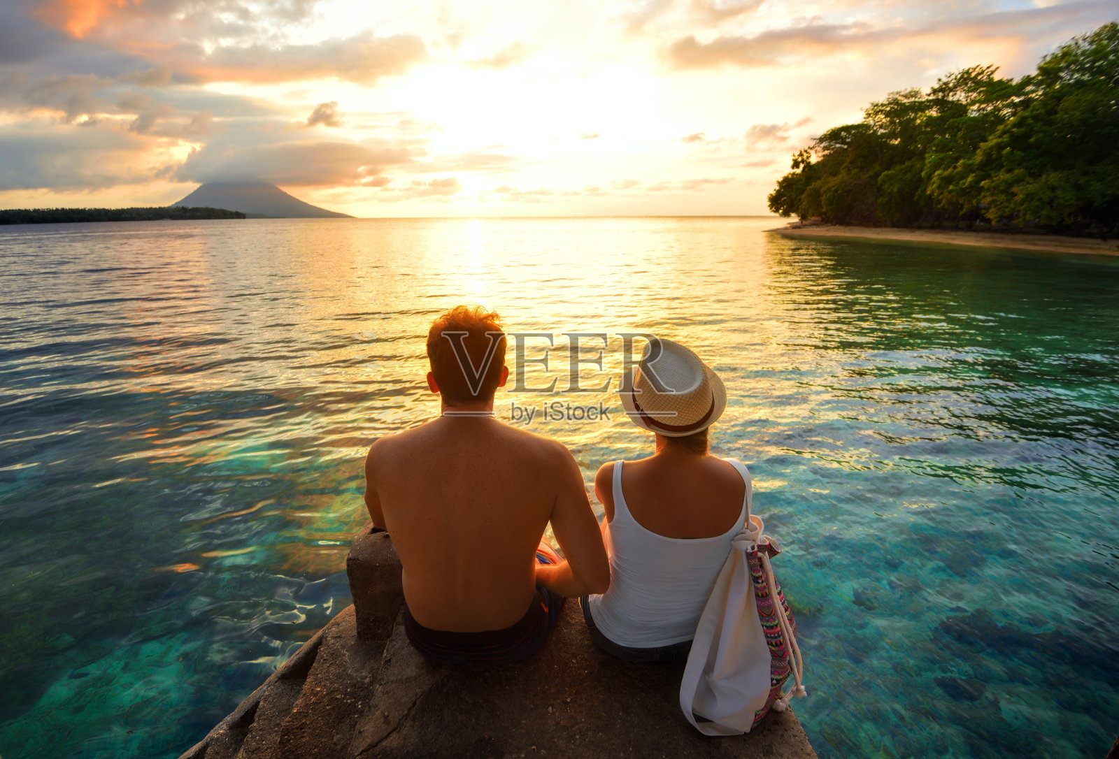 幸福的夫妇在码头上的背景彩色日落照片摄影图片