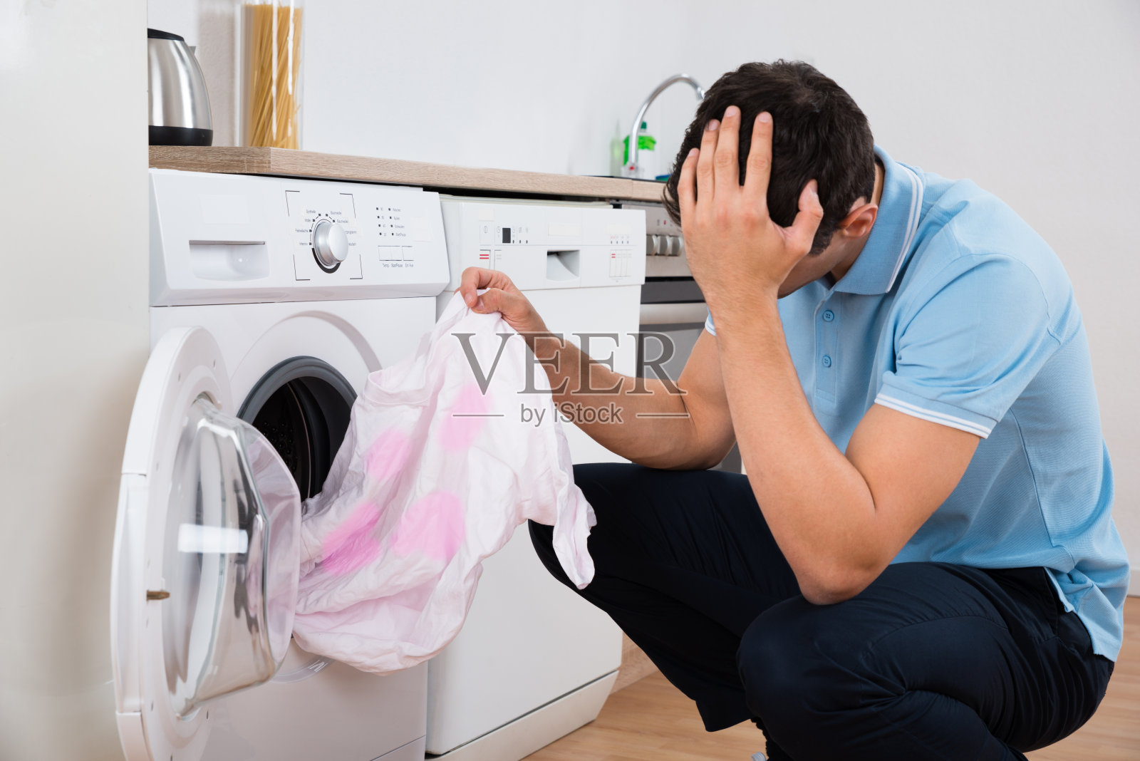紧张的人拿着脏t恤洗衣机照片摄影图片