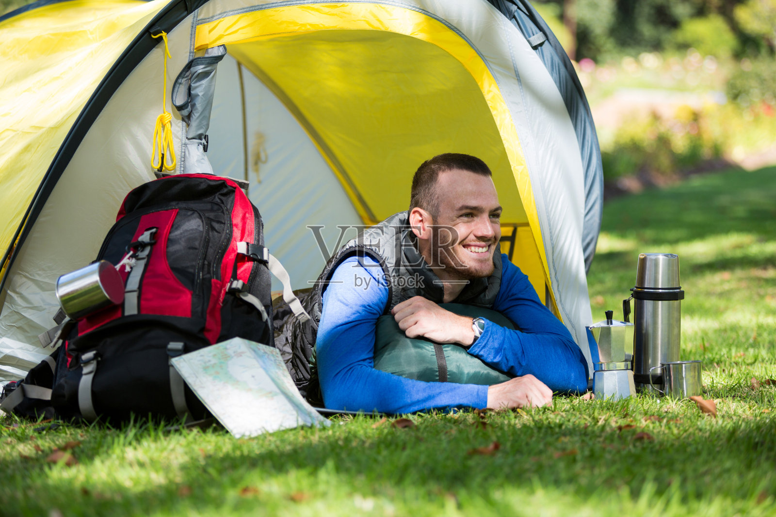 微笑的徒步旅行者躺在帐篷里照片摄影图片