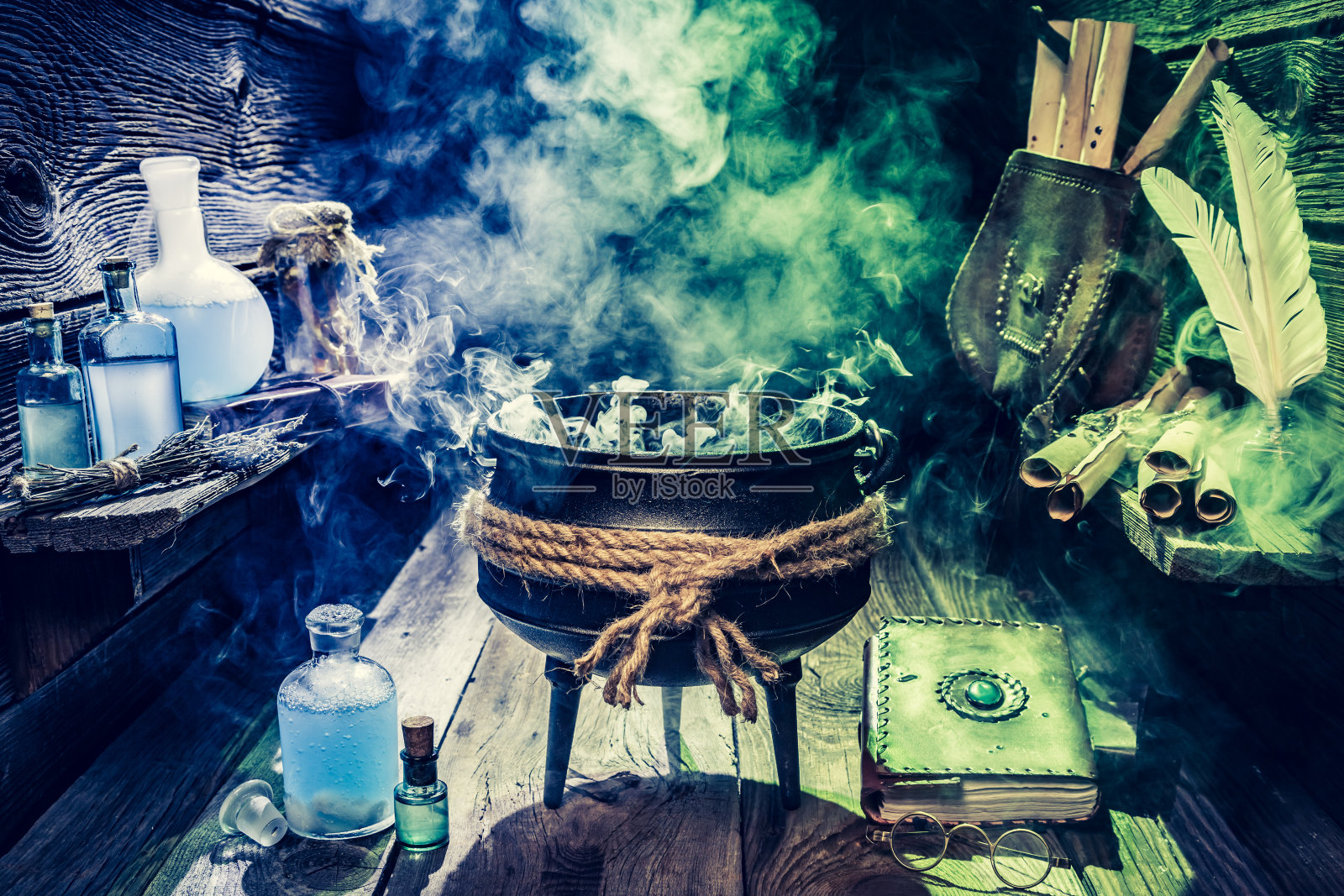 装满魔法混合物的女巫壶与蓝色的药水照片摄影图片