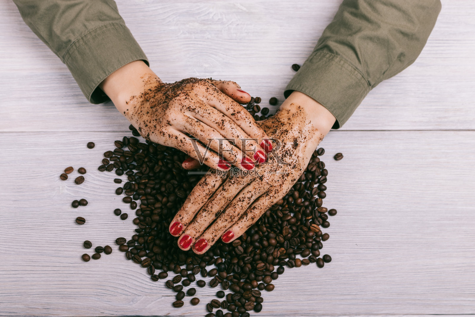 女性用红色指甲油涂抹了咖啡磨砂膏照片摄影图片