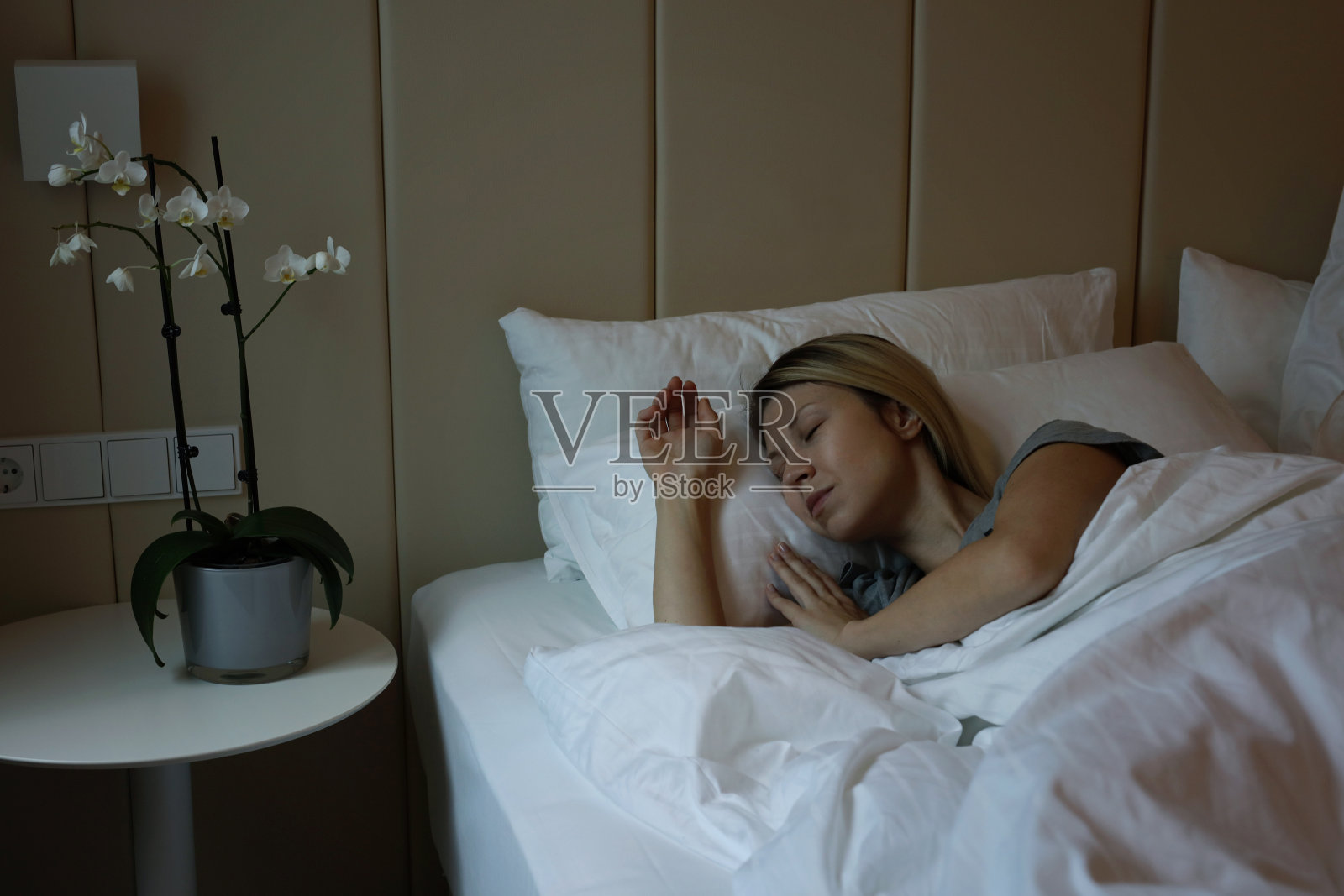 年轻漂亮的女人舒舒服服地睡在床上照片摄影图片