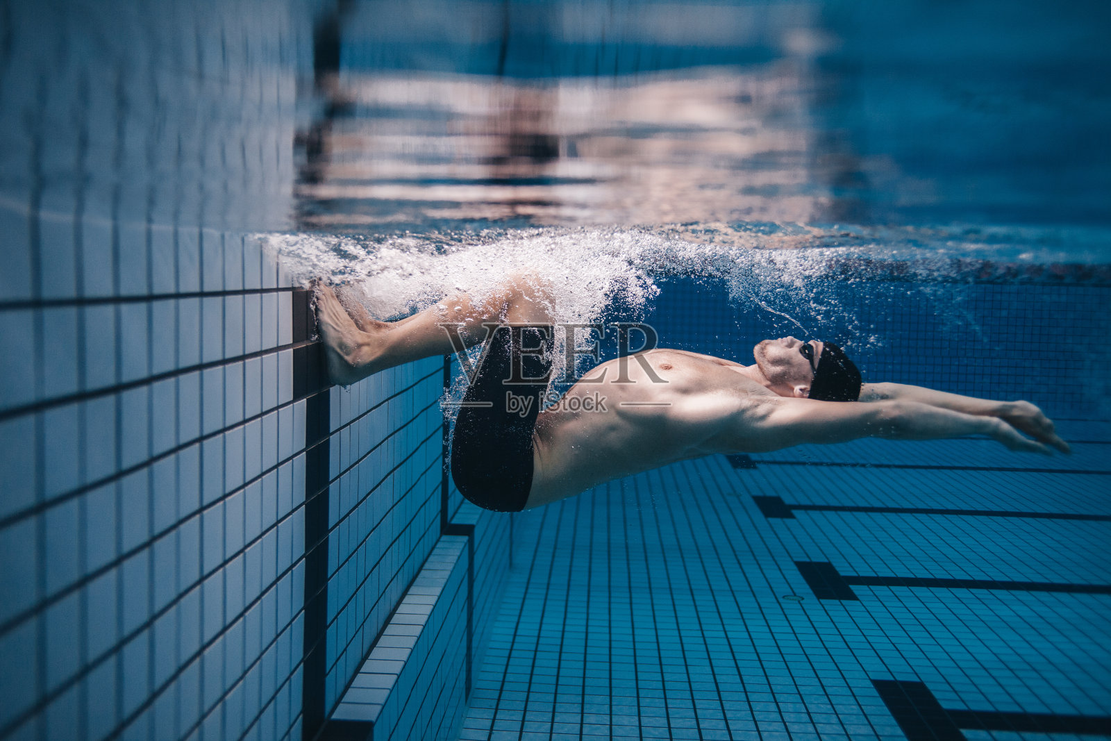职业男性游泳运动员在游泳池内的行动照片摄影图片