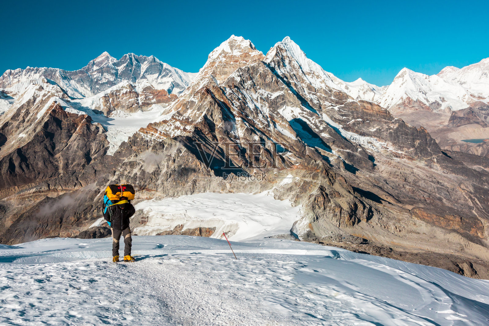 登山者攀登高海拔山峰行走在雪域地形上照片摄影图片