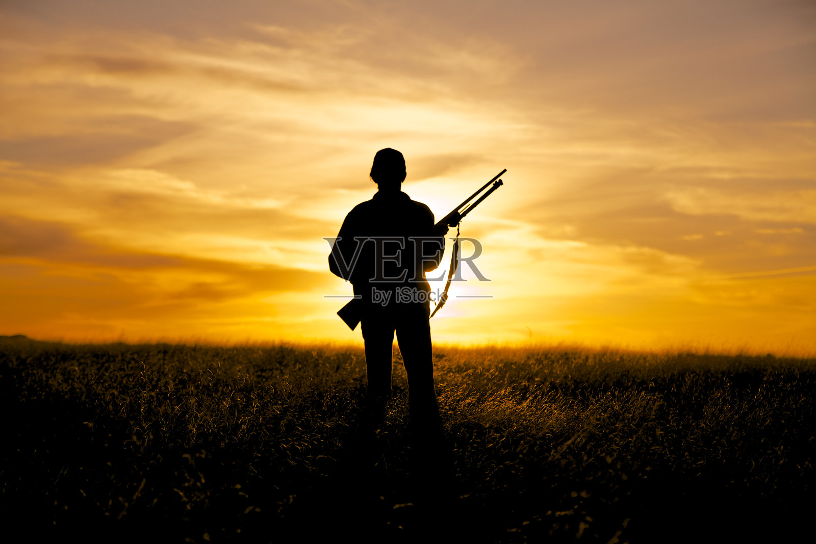 日落中的女子猎人和步枪照片摄影图片