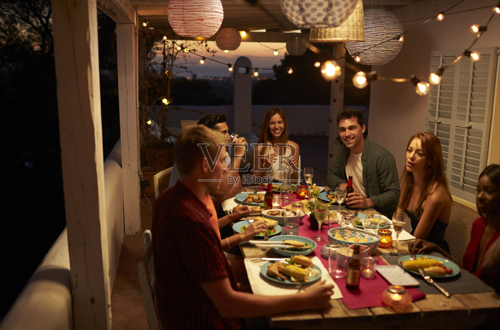 西班牙伊比沙岛，朋友们在院子里的晚餐聚会上聊天照片摄影图片