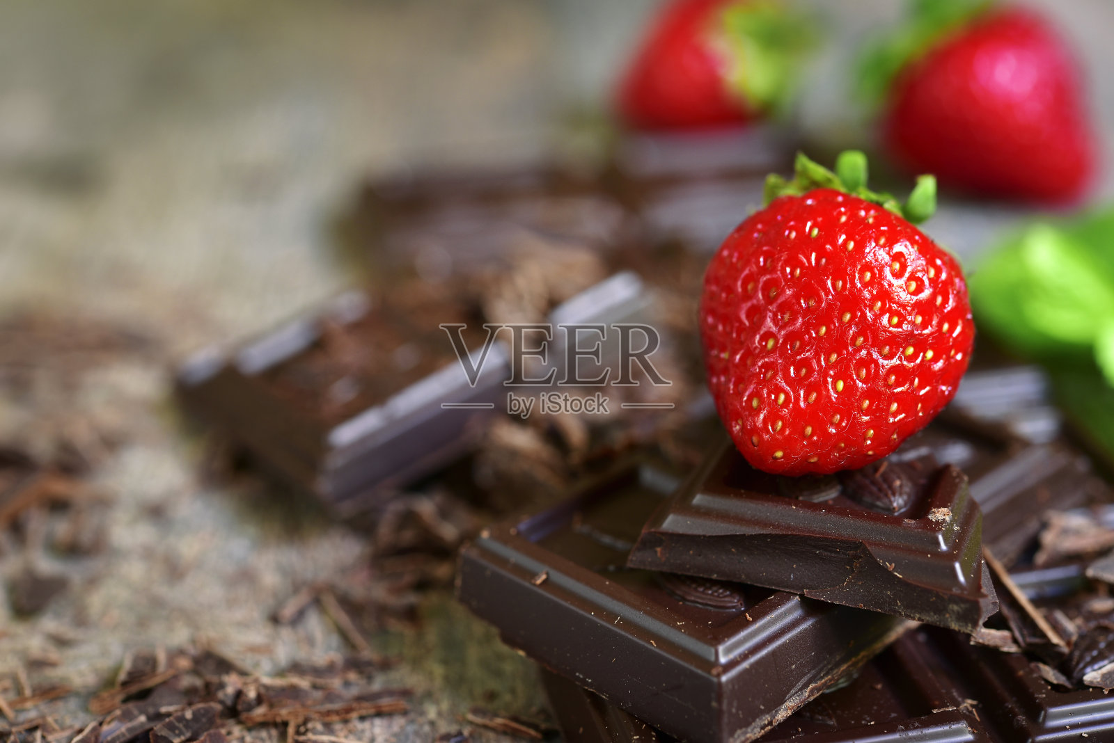 一堆巧克力片和新鲜成熟的草莓。照片摄影图片