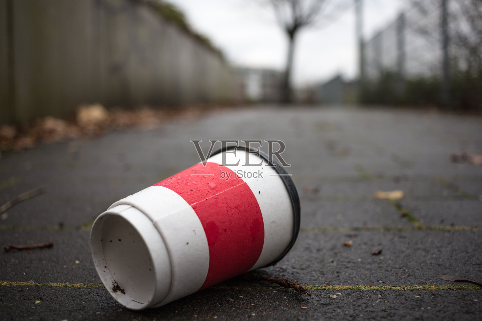 用过的咖啡杯放在人行道上作为污染的象征。照片摄影图片