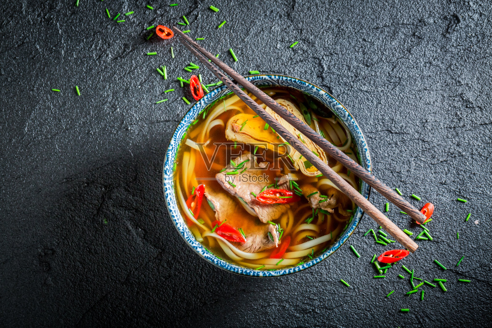 美味的红咖喱汤，用筷子夹在黑碗里照片摄影图片