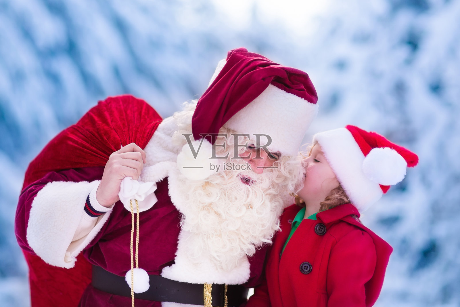 圣诞老人在白雪覆盖的公园里和小女孩聊天照片摄影图片