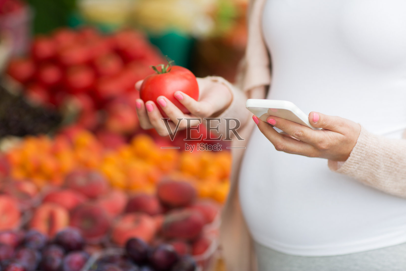 一名孕妇在街头市场拿着智能手机照片摄影图片