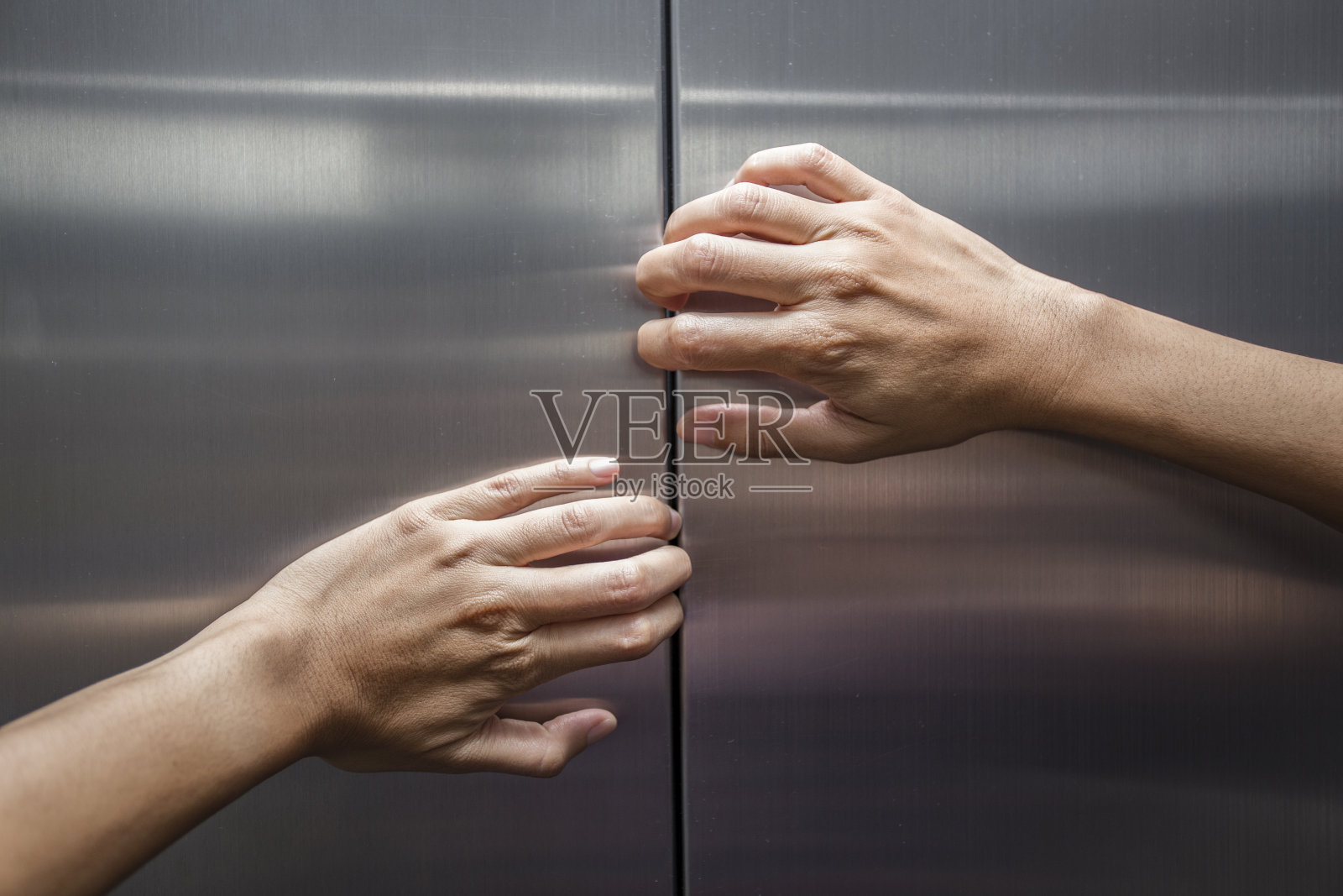 女人的手试图阻止关闭的电梯门照片摄影图片