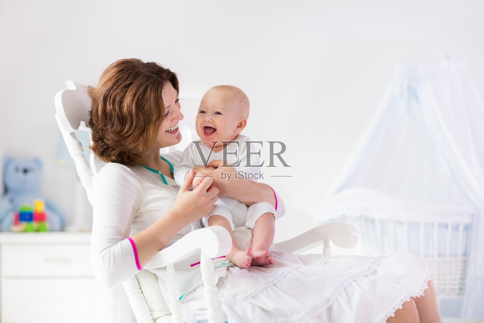 母亲和婴儿在白色的卧室照片摄影图片