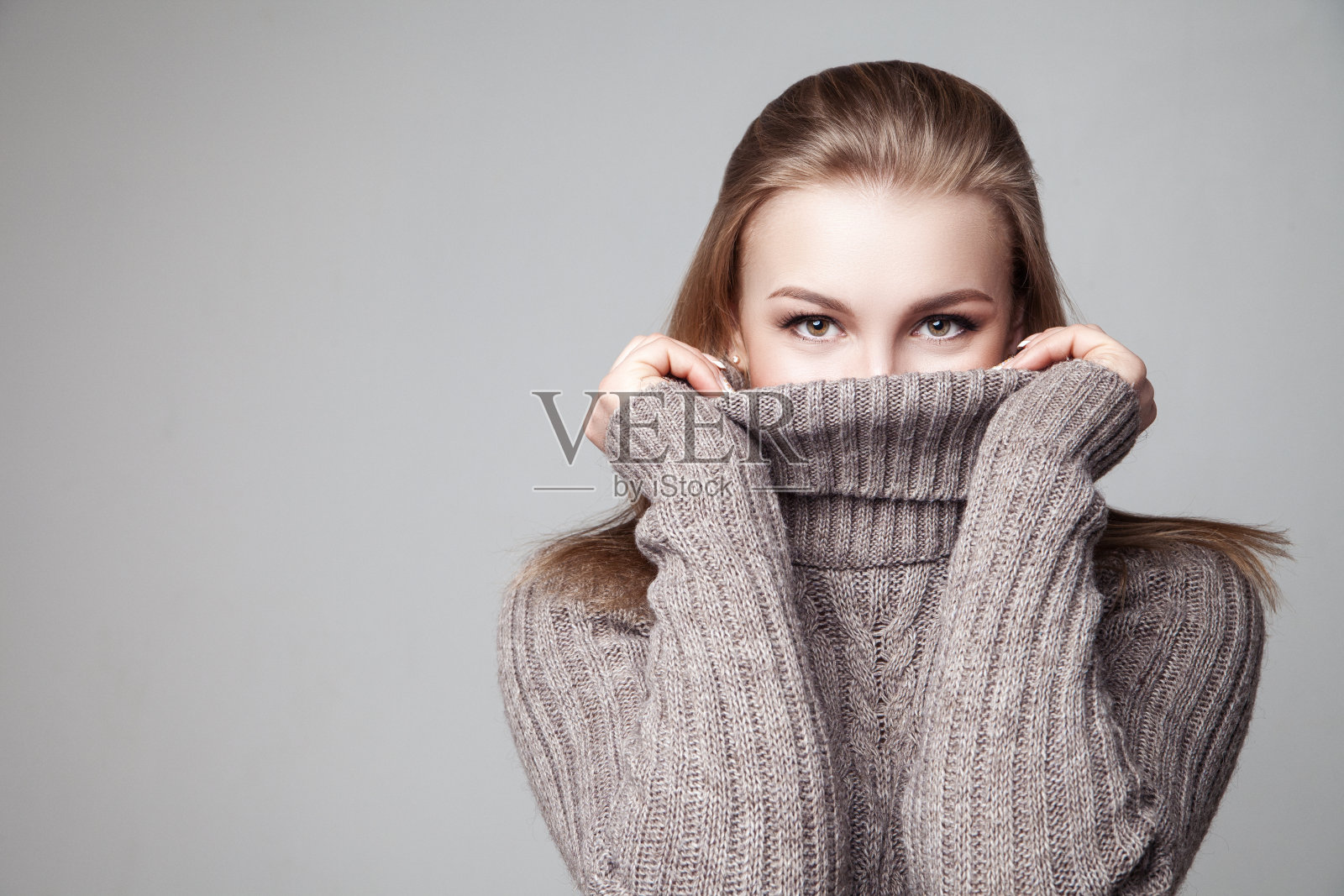 漂亮的金发小女孩穿着冬天的套头毛衣照片摄影图片