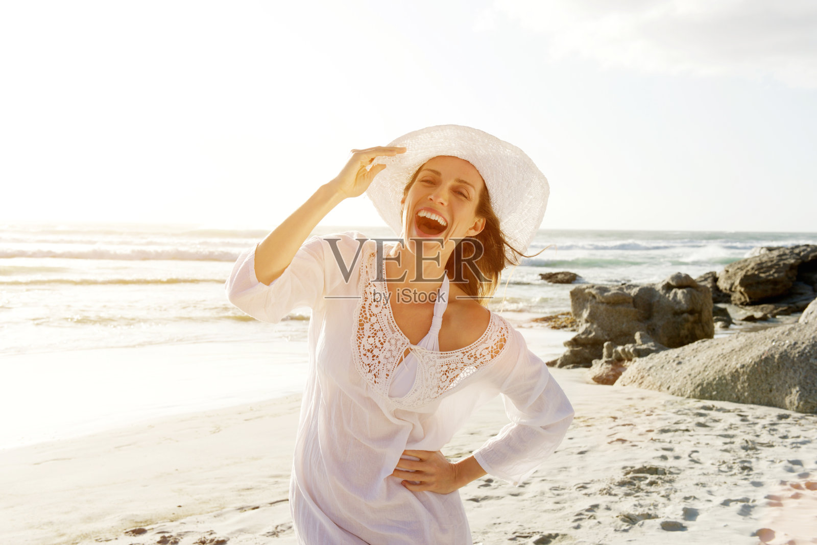 无忧无虑的女人走在海滩上太阳裙和帽子照片摄影图片