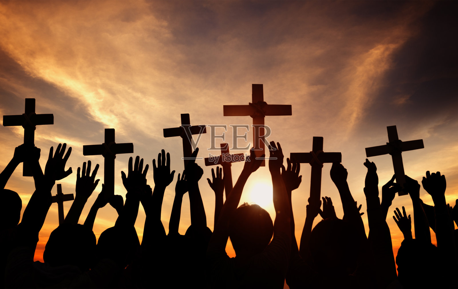 一群人抱着十字架，在背光祈祷照片摄影图片