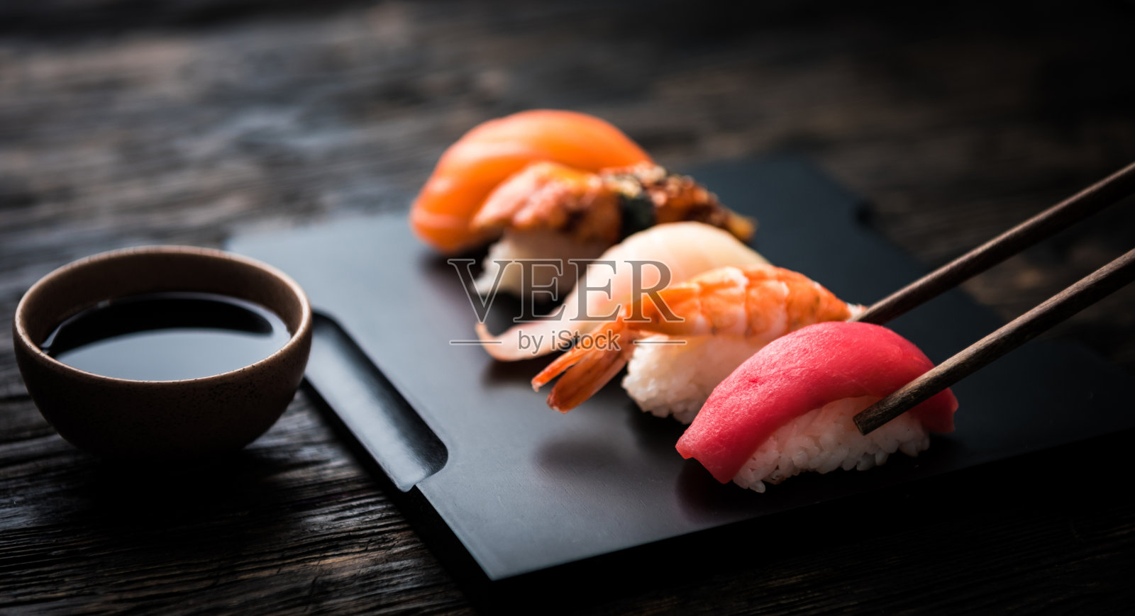 近距离的生鱼片寿司与筷子和酱油照片摄影图片