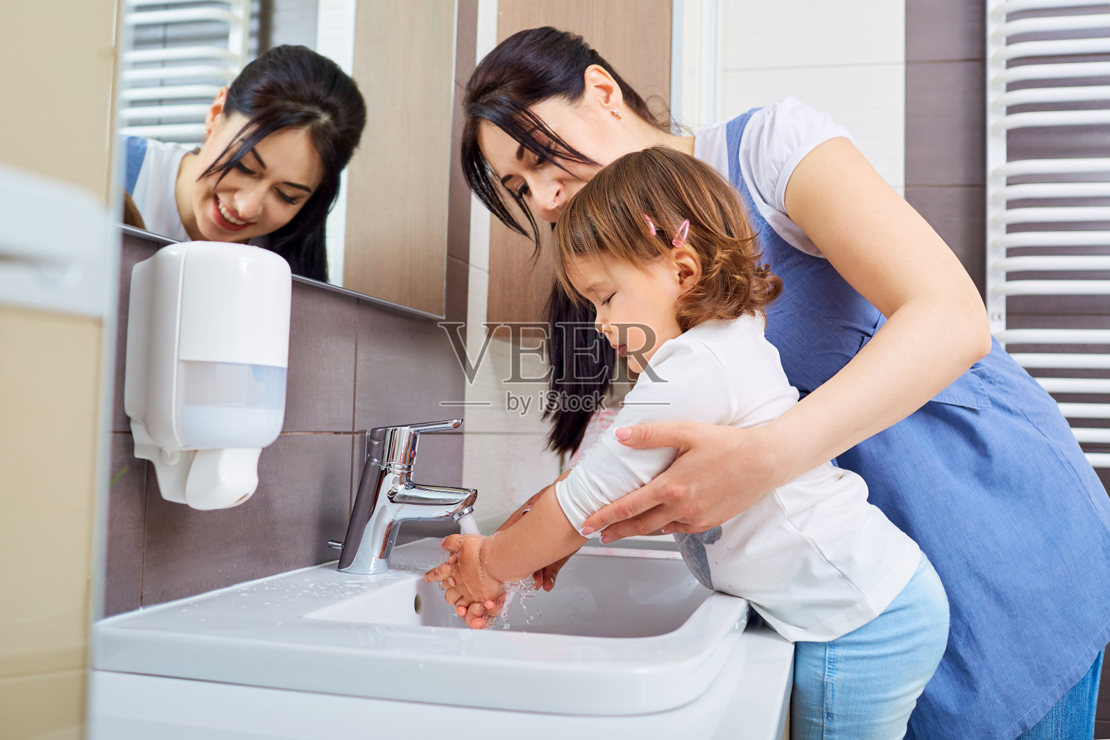 孩子和妈妈在浴室洗手。照片摄影图片