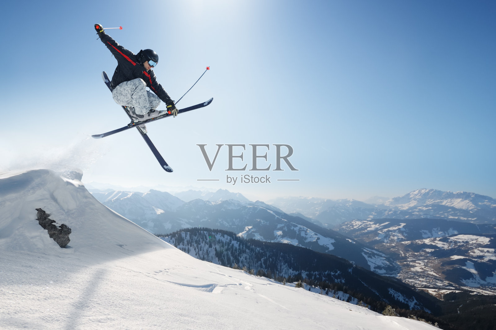 雪山上的跳跃滑雪者照片摄影图片