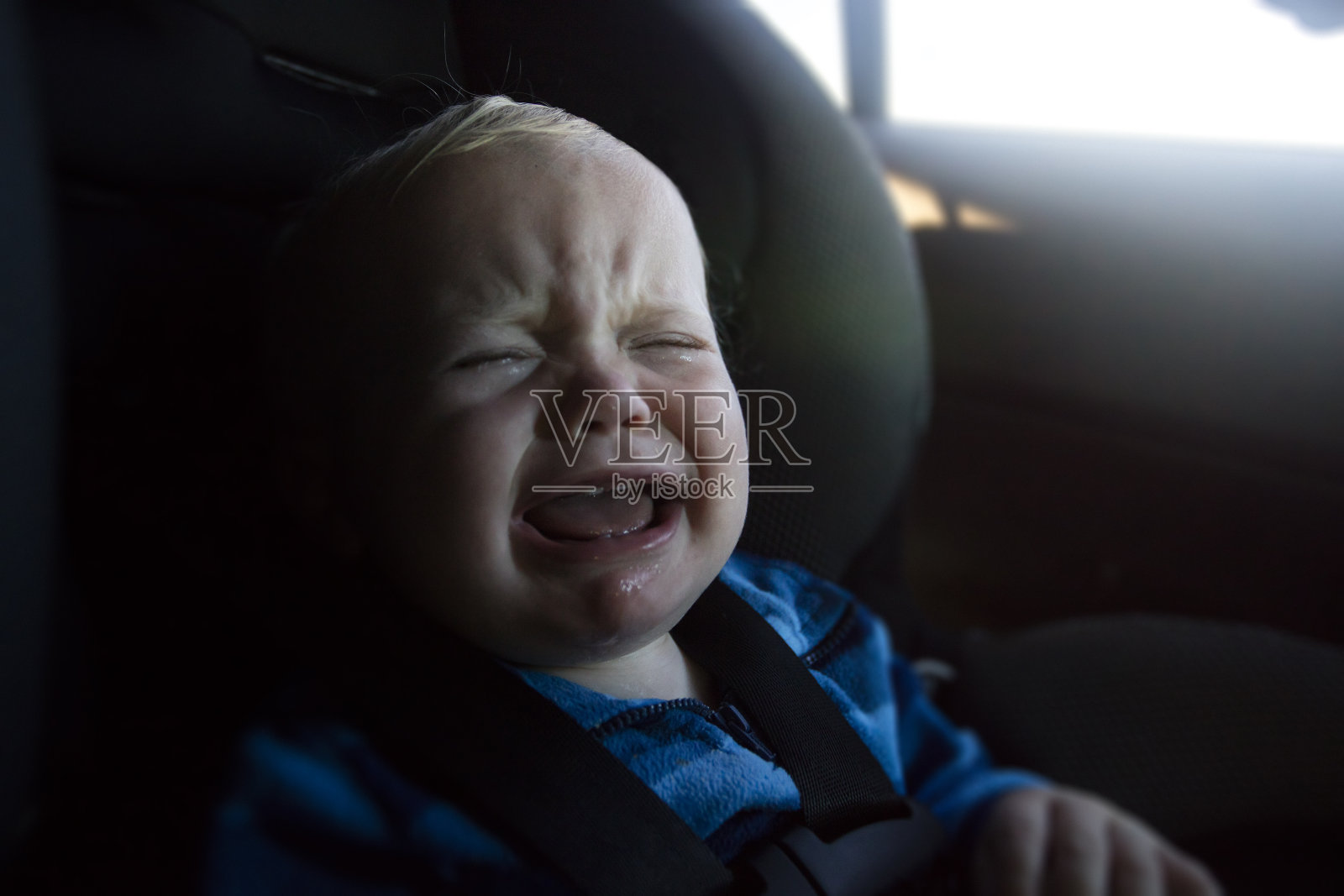 小男孩在汽车座椅上哭照片摄影图片