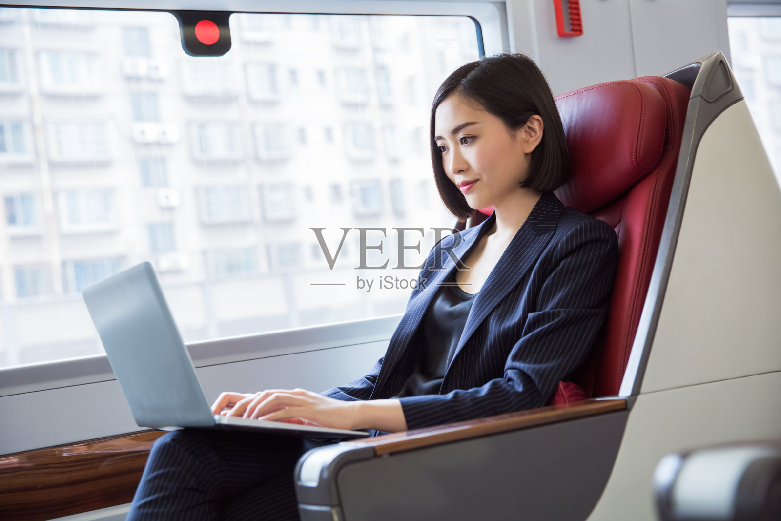 中国上海，美丽的女商人坐在高铁里。照片摄影图片