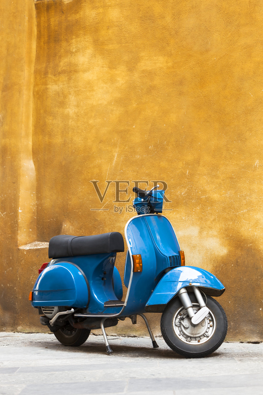 意大利托斯卡纳，经典蓝色踏板车对抗黄色垃圾墙照片摄影图片