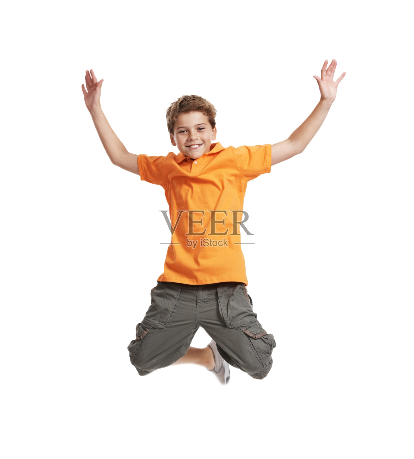 小男孩很兴奋，在白色的背景上在半空中跳跃照片摄影图片