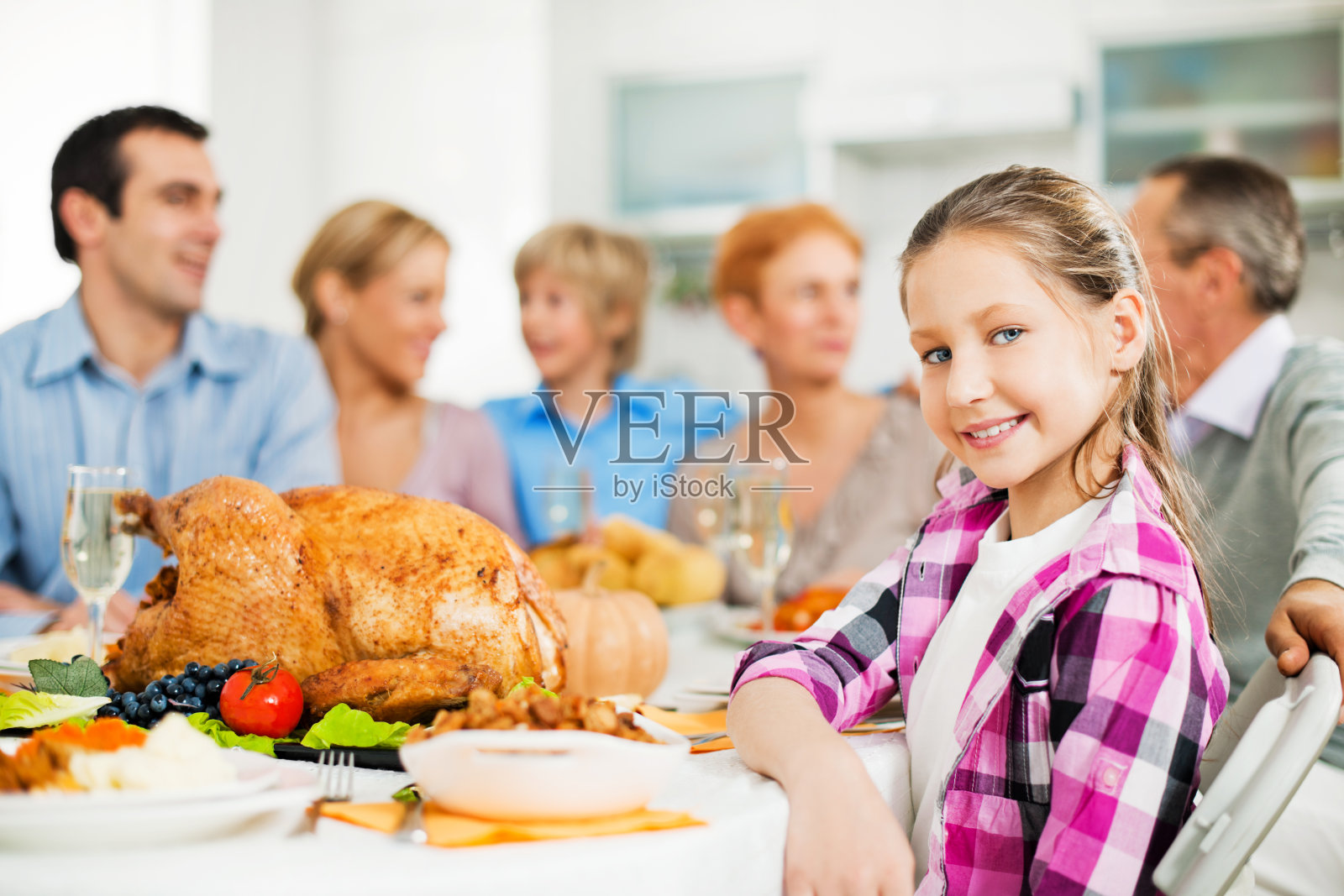 感恩节一家人围坐在餐桌旁。照片摄影图片