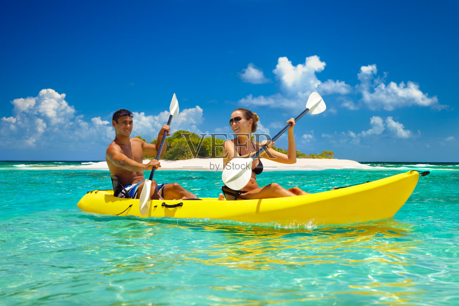 一对夫妇在加勒比海的一个热带岛屿上划皮划艇照片摄影图片