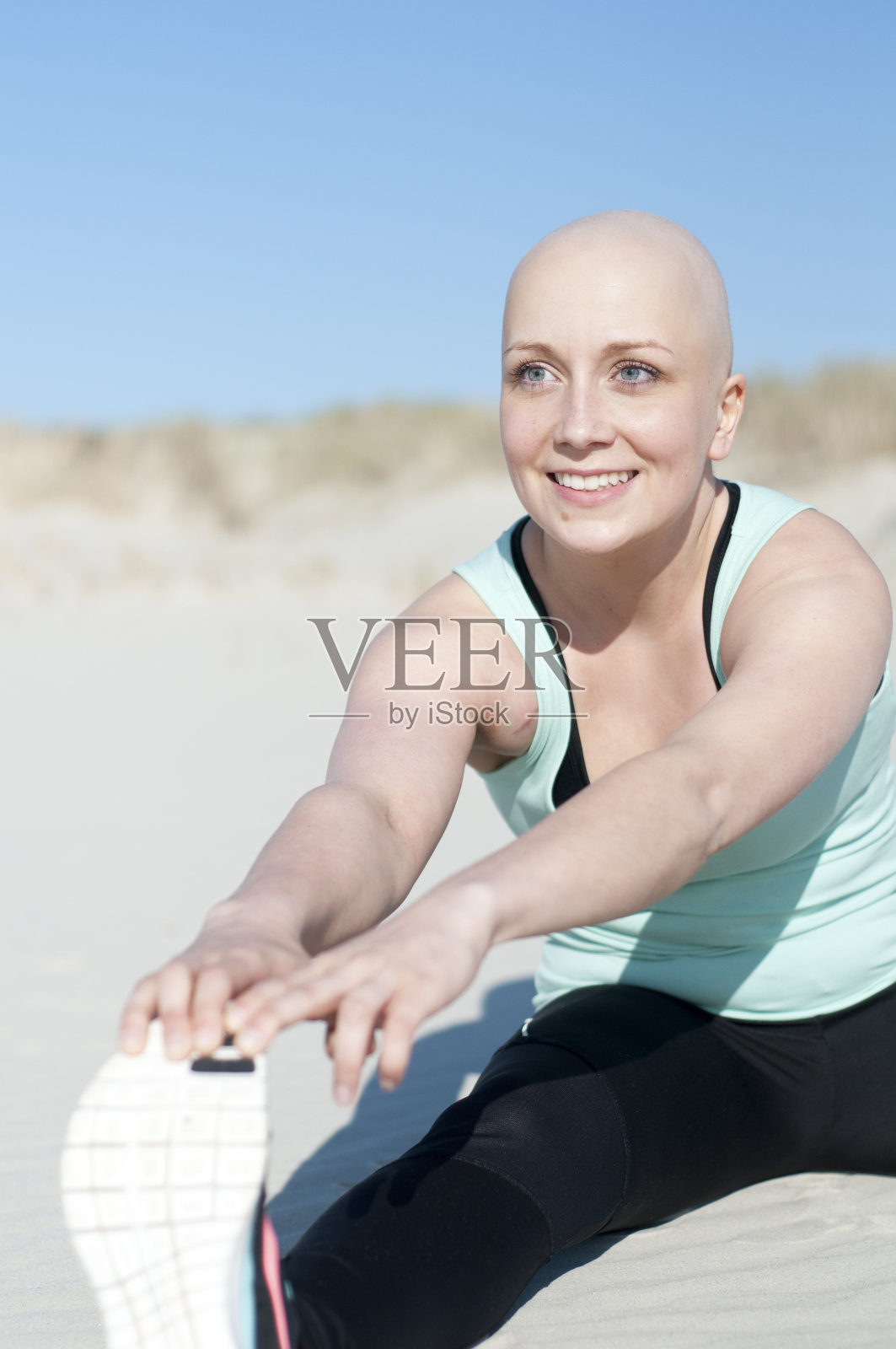 年轻的秃头女子在接受化疗后做运动照片摄影图片
