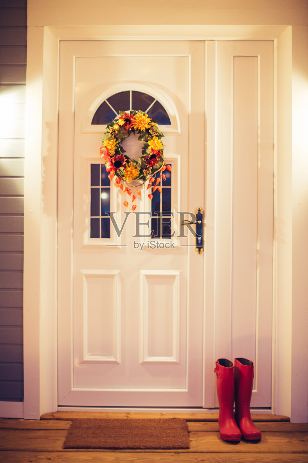 秋花环挂在门上。照片摄影图片