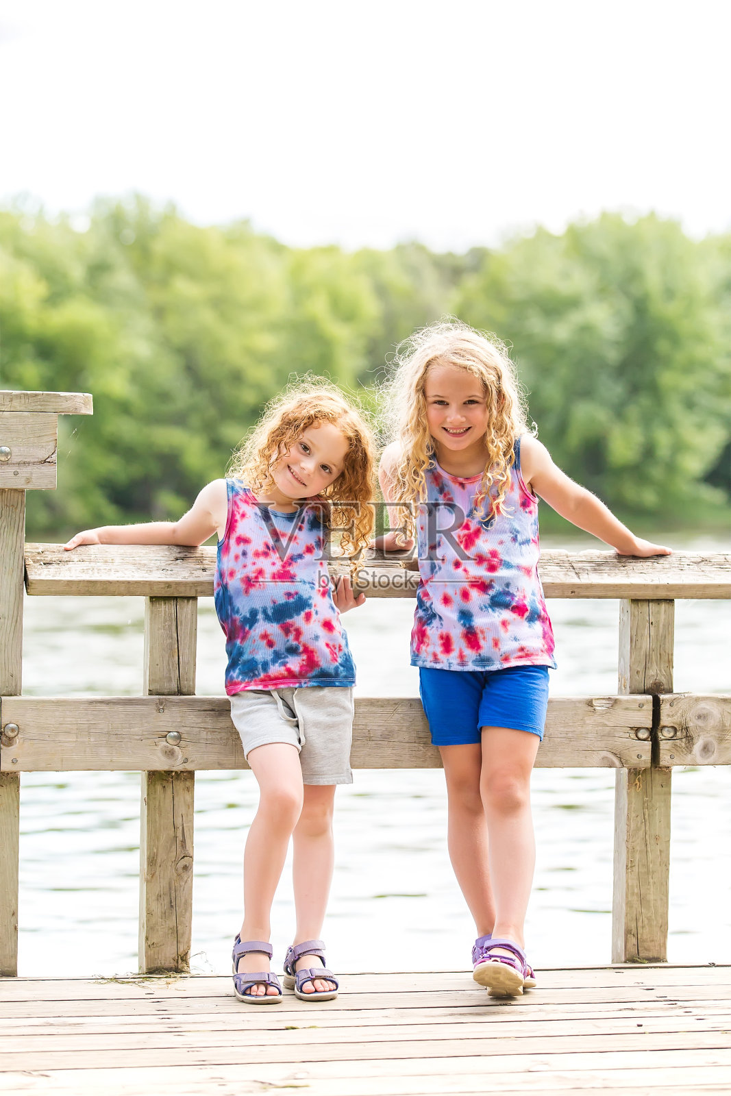 夏日里站在码头上的两个年轻女孩照片摄影图片