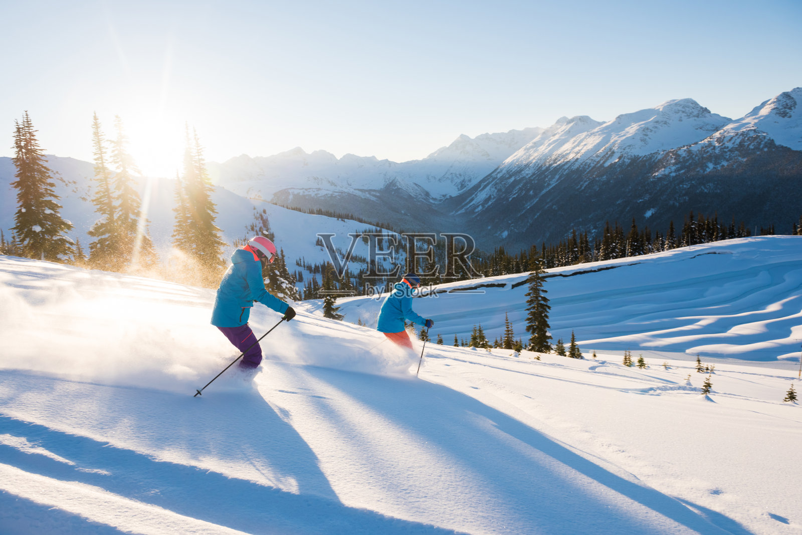一对夫妇在阳光明媚的雪天滑雪照片摄影图片