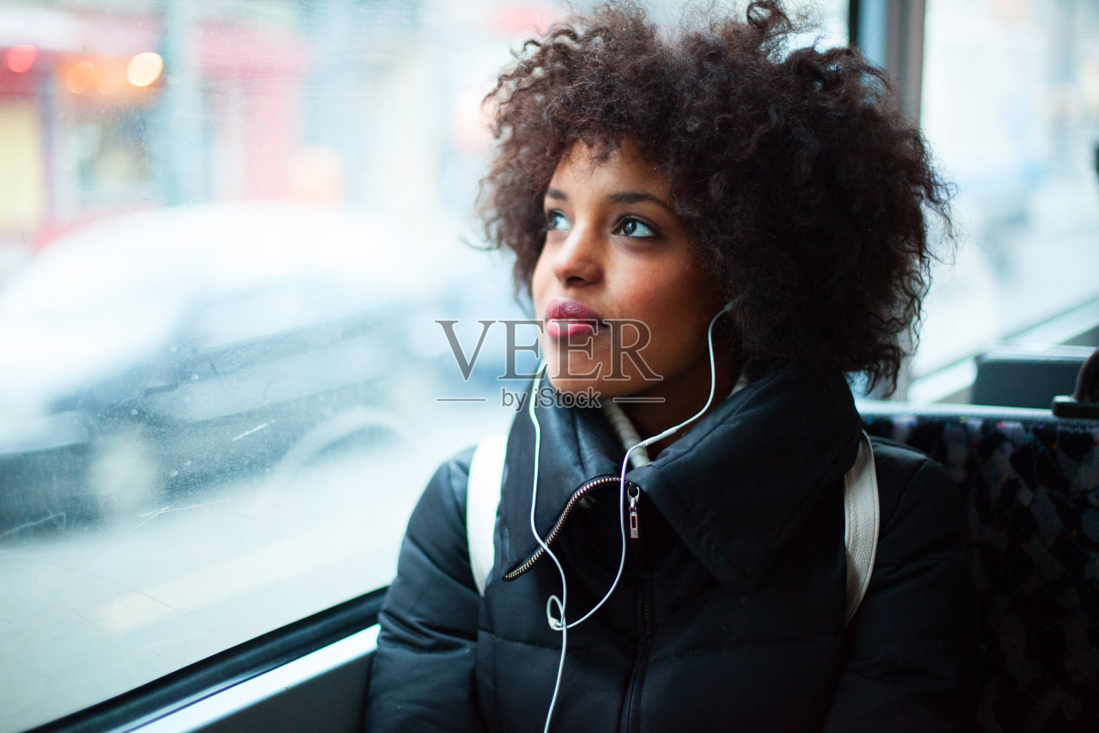 年轻女孩在公共交通工具上听音乐照片摄影图片