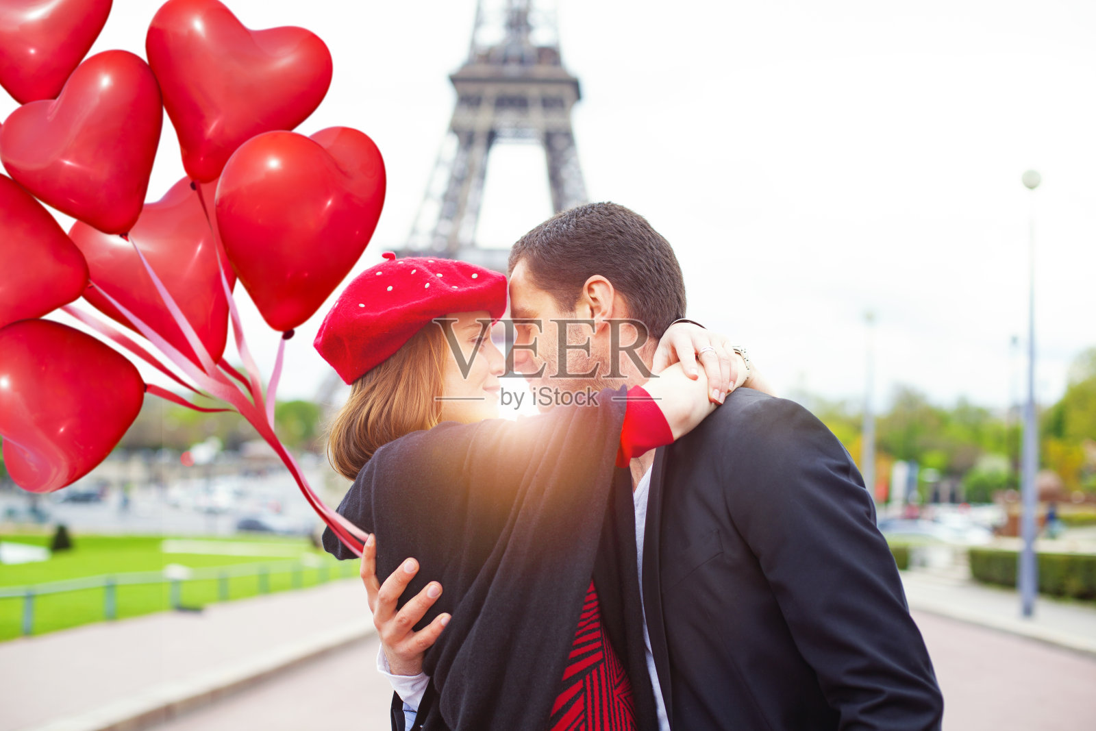 在巴黎的埃菲尔铁塔上，这对浪漫的情侣拥抱着彼此的鼻子照片摄影图片