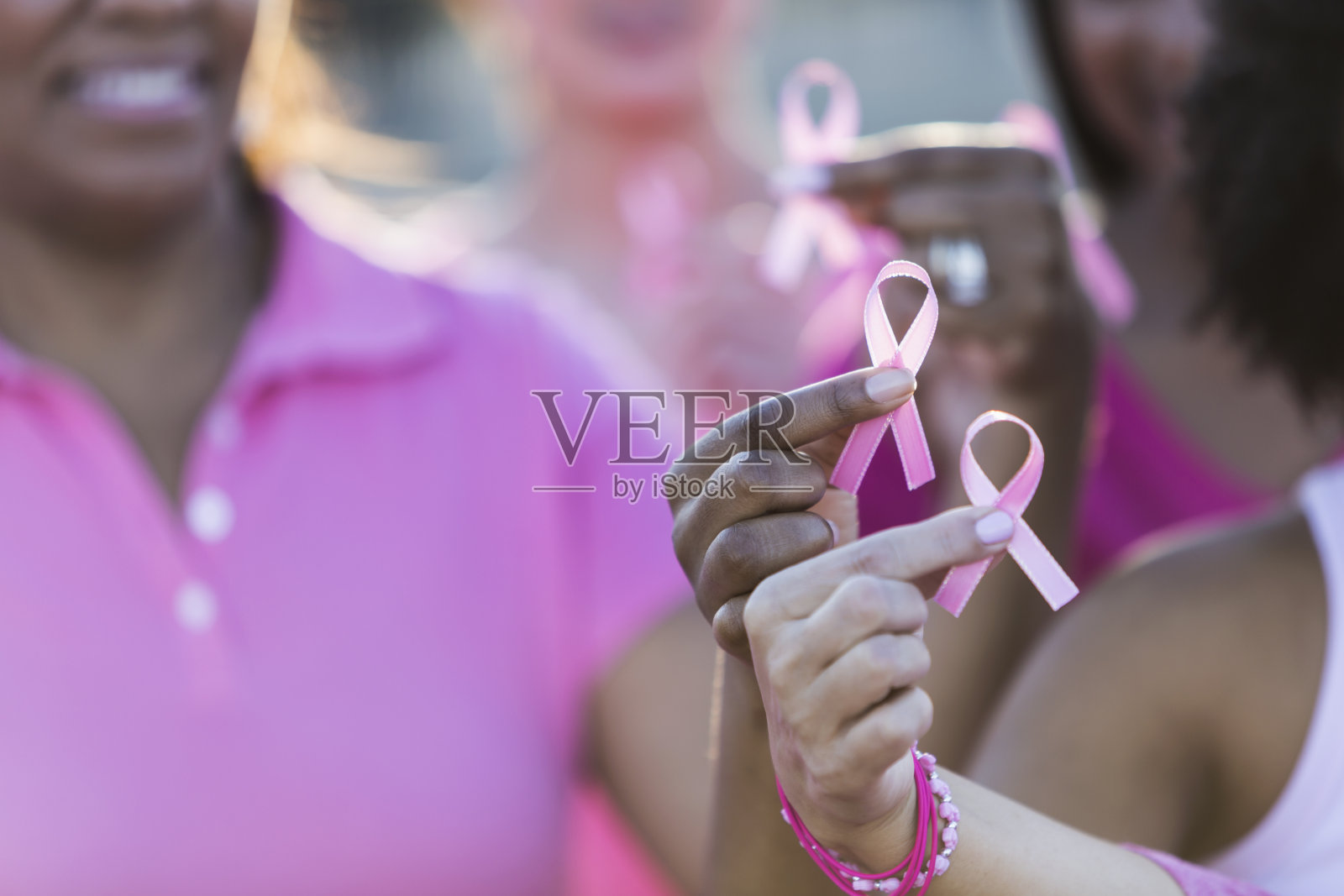 多种族手握乳腺癌意识丝带照片摄影图片