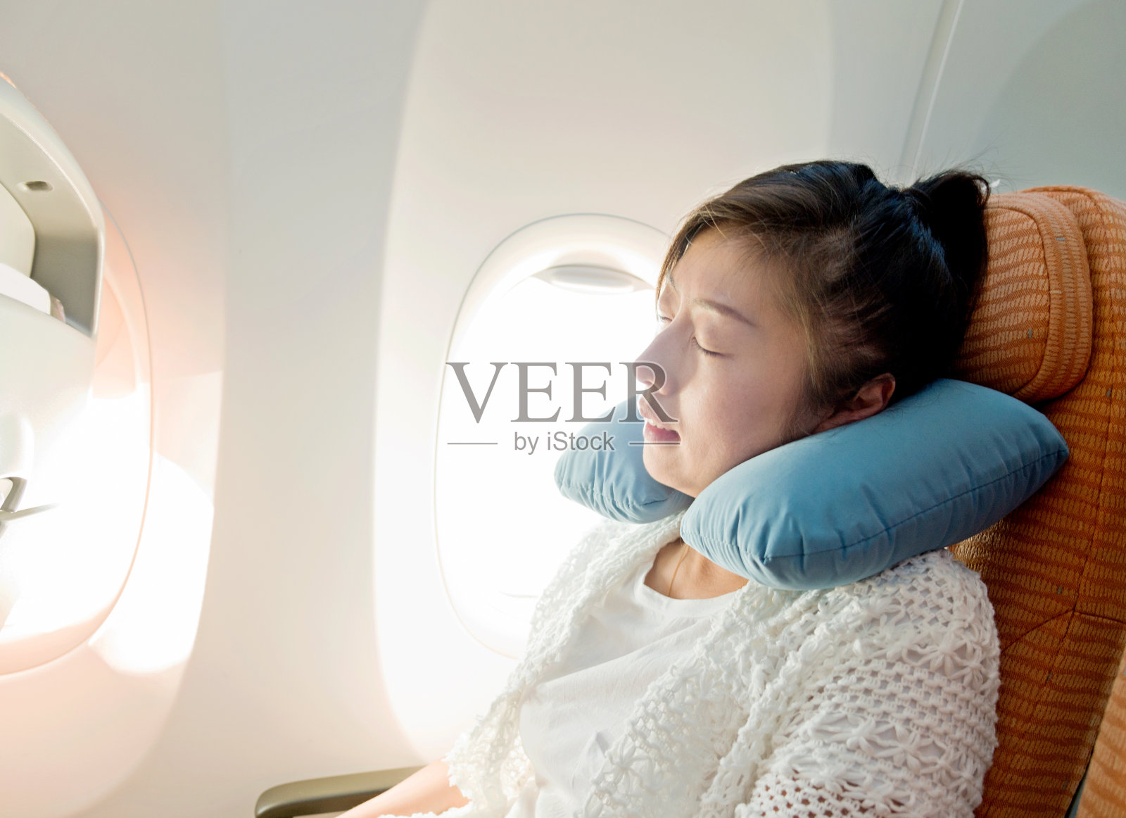 年轻的亚洲女人在飞机上睡觉照片摄影图片