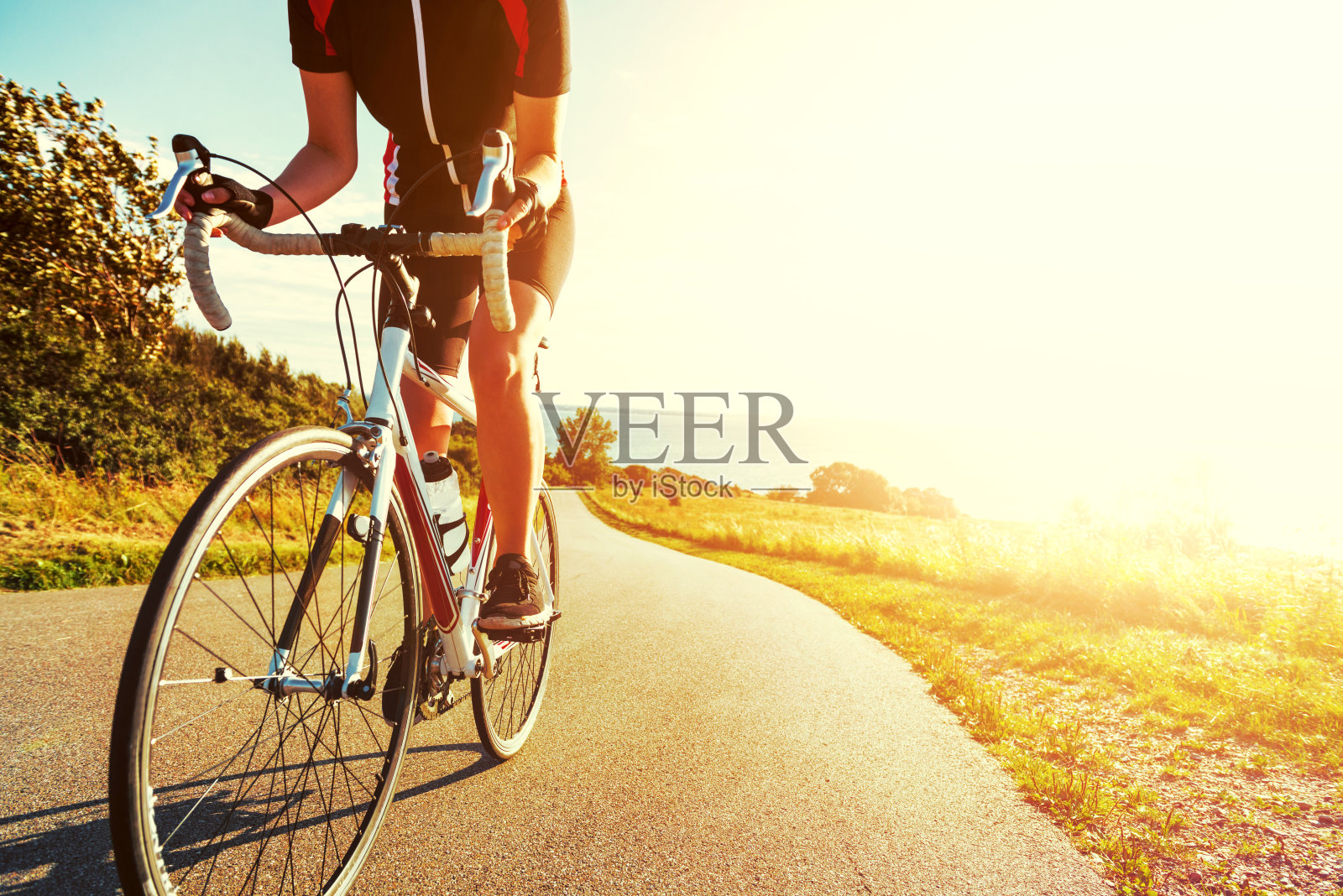 日落时分，职业运动员骑自行车上山照片摄影图片