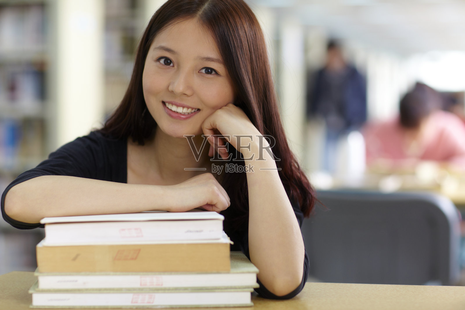 一个漂亮的亚洲女大学生在图书馆学习照片摄影图片