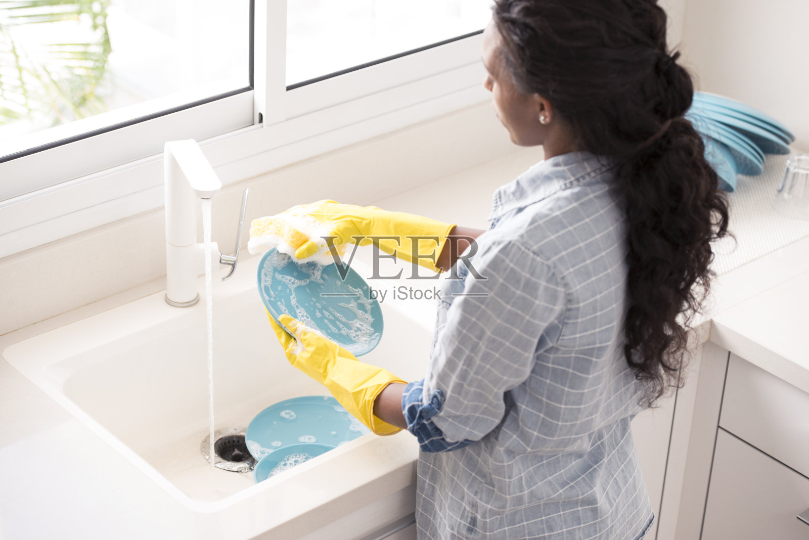 洗碗的女人。照片摄影图片