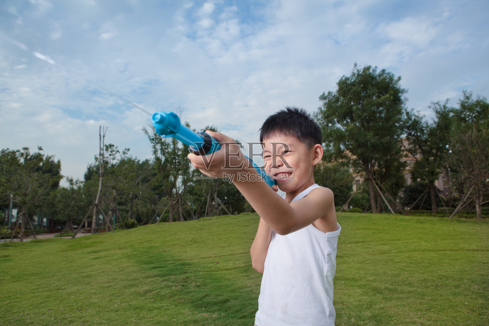 亚洲男孩玩水枪照片摄影图片