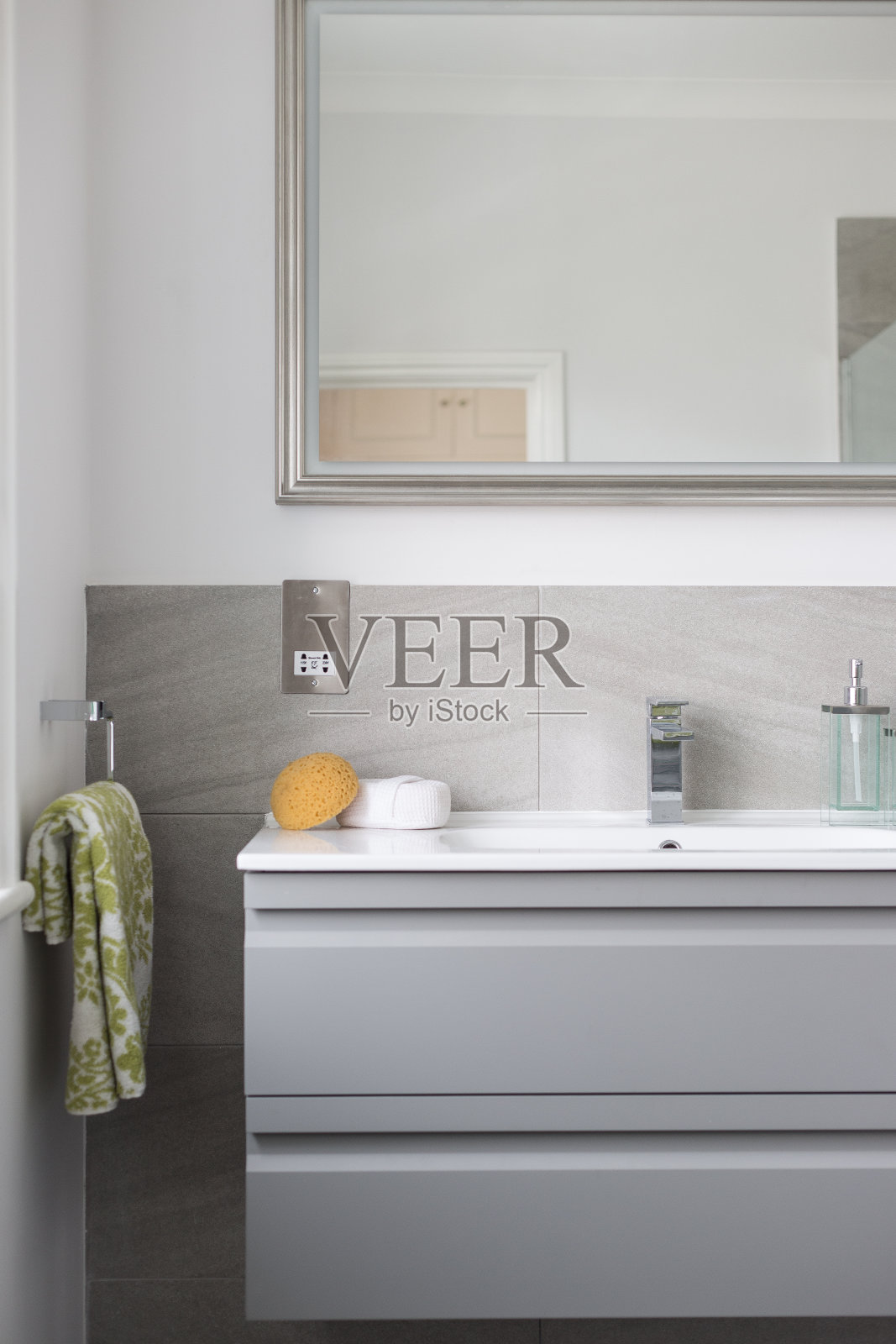 一个现代和干净的浴室水槽，镜子，海绵和毛巾照片摄影图片