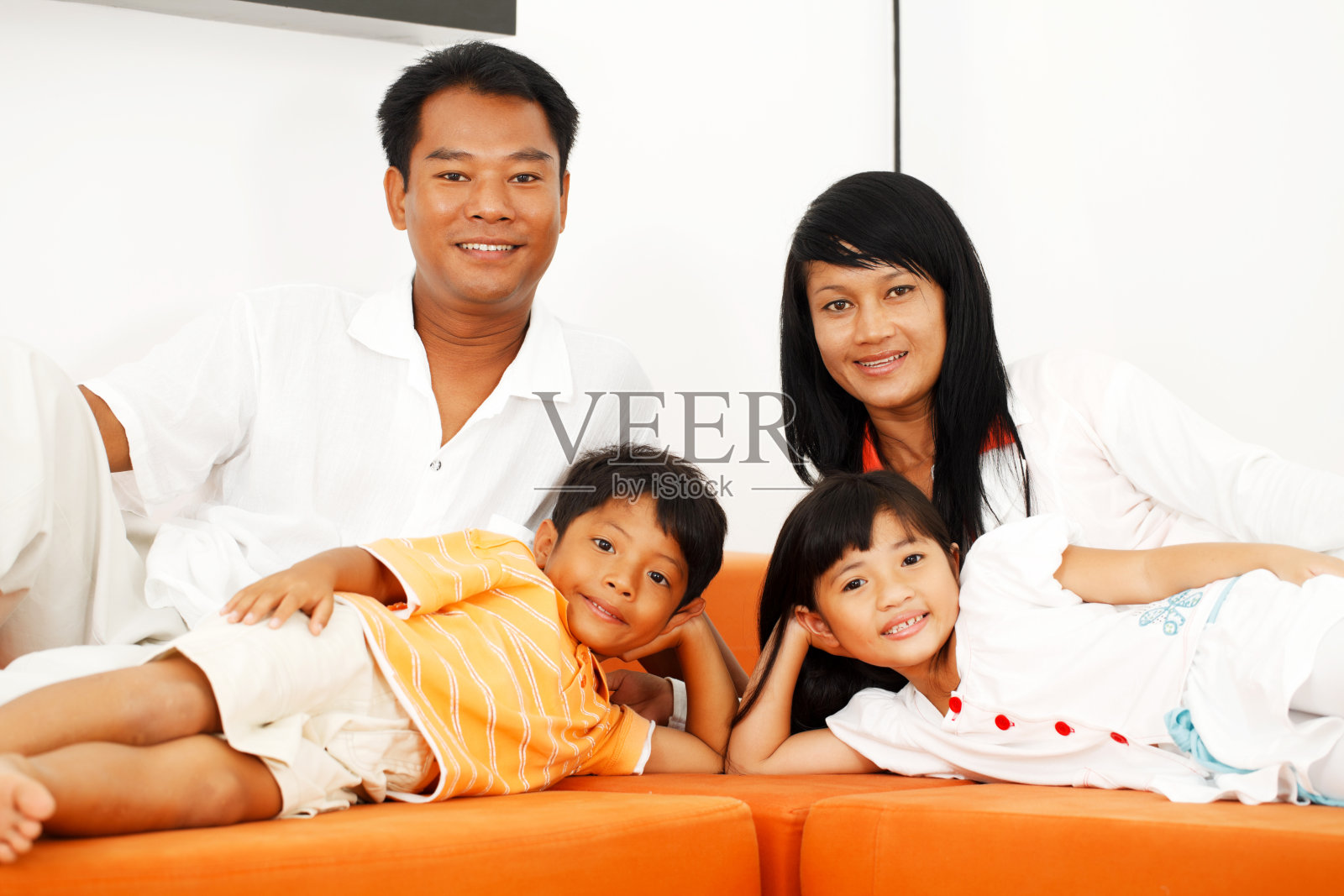 泰国一家人躺在客厅的沙发上。照片摄影图片