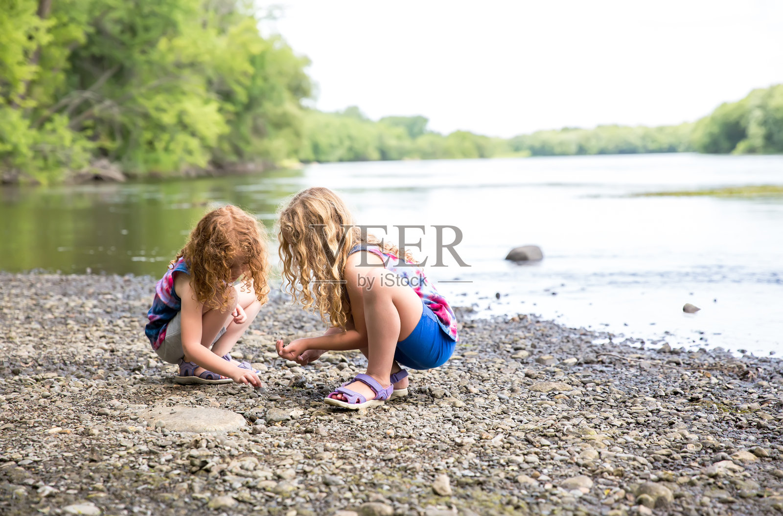 在密西西比河岸边玩耍的两个女孩照片摄影图片