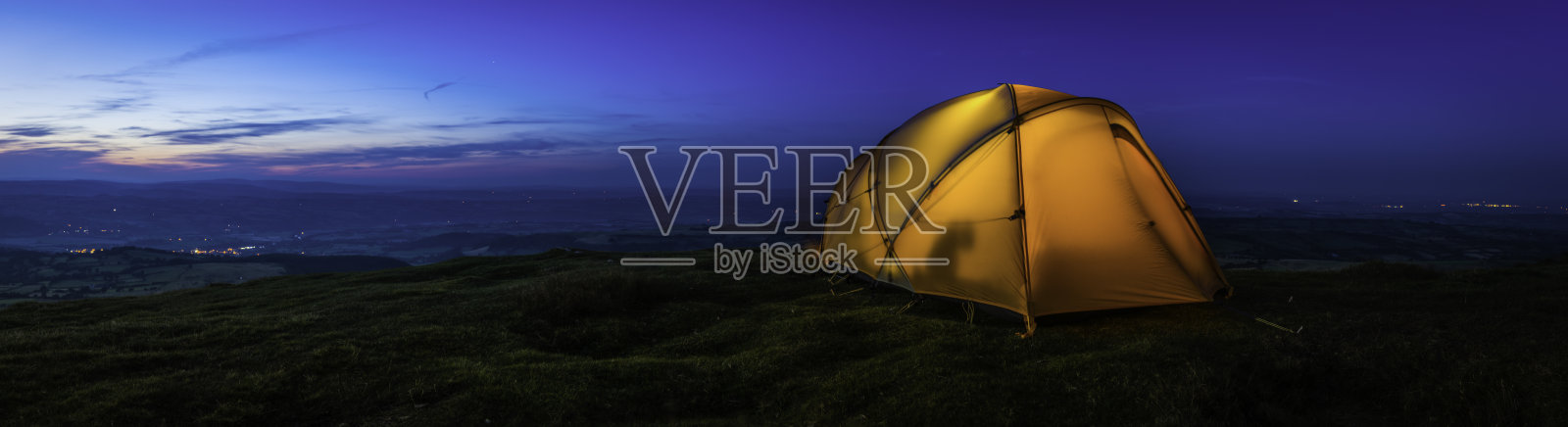 温暖的灯光帐篷在山脊俯瞰日落山谷全景照片摄影图片
