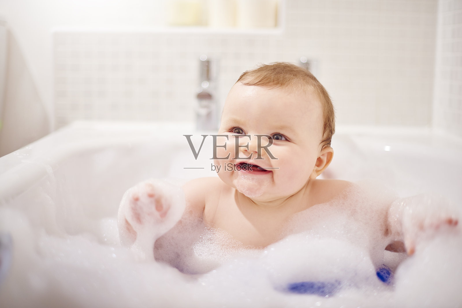 小男孩在他的泡泡浴里笑照片摄影图片