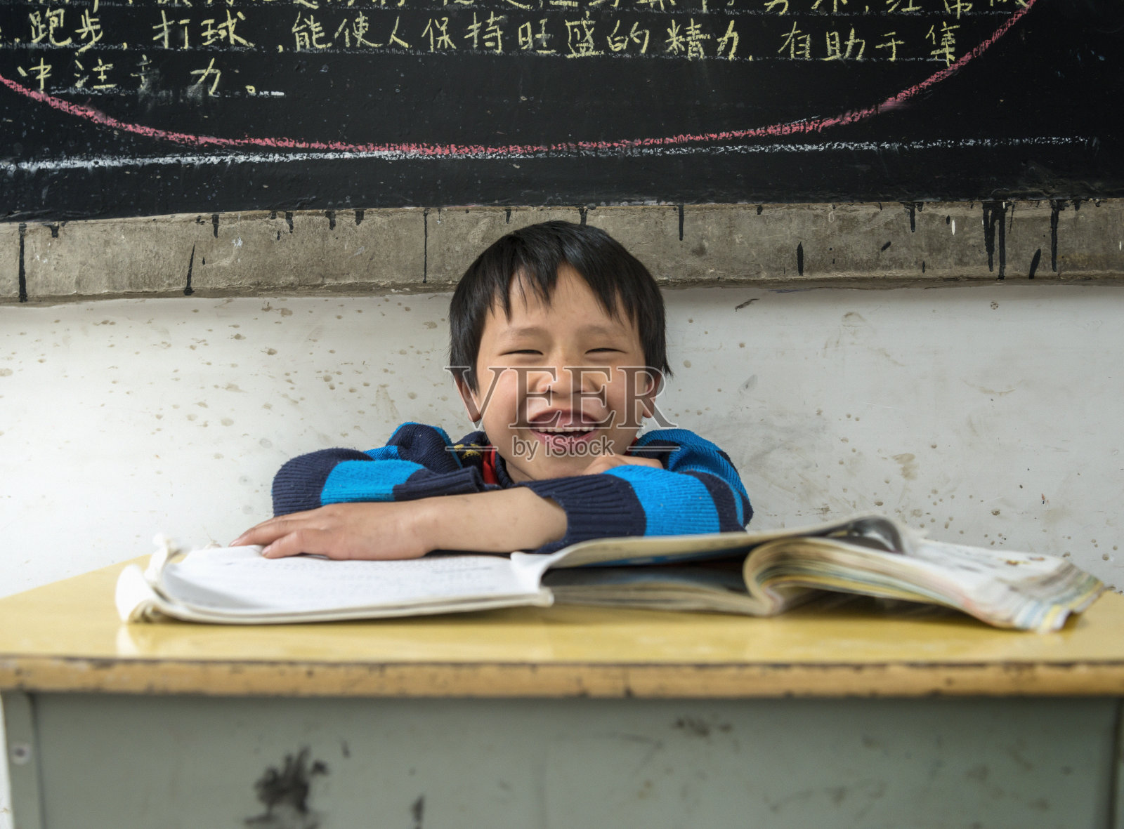 中国男孩，笑着，双臂交叉照片摄影图片