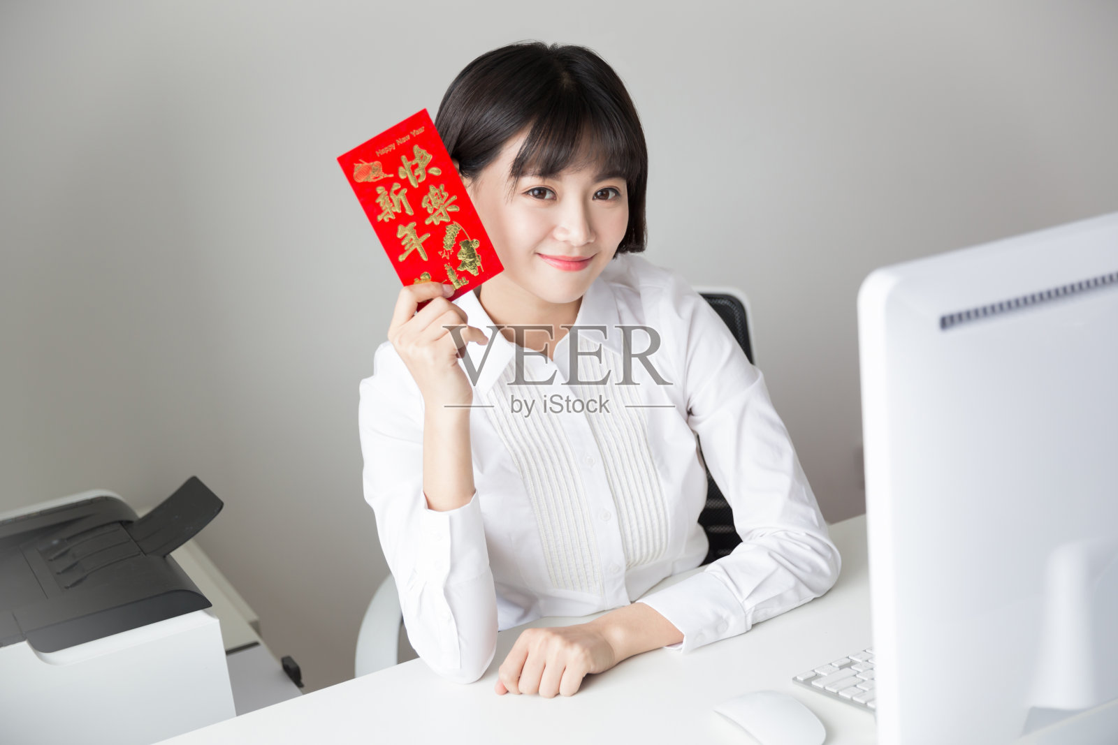 穿着白衬衫的女孩拿着红包在办公室里照片摄影图片